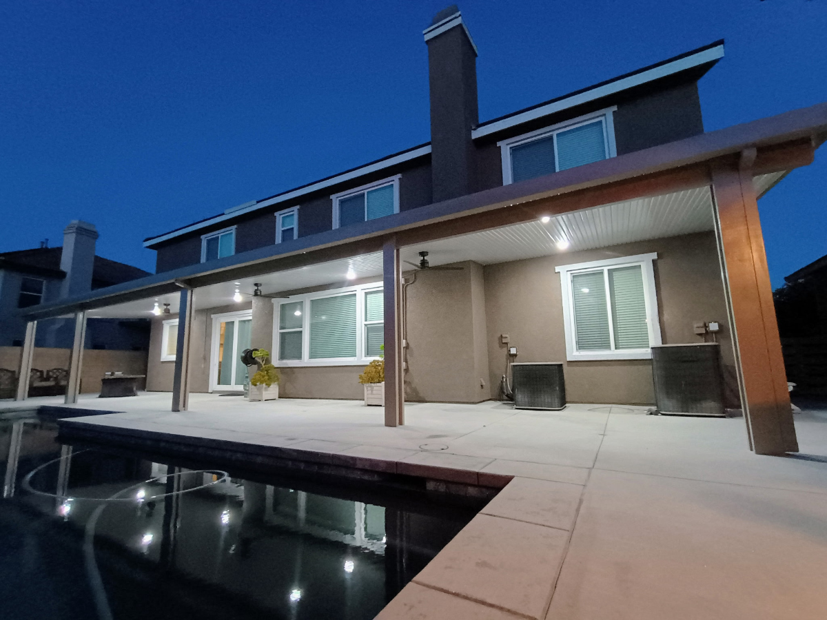 Open-beam aluminum patio cover allowing filtered sunlight through the structure