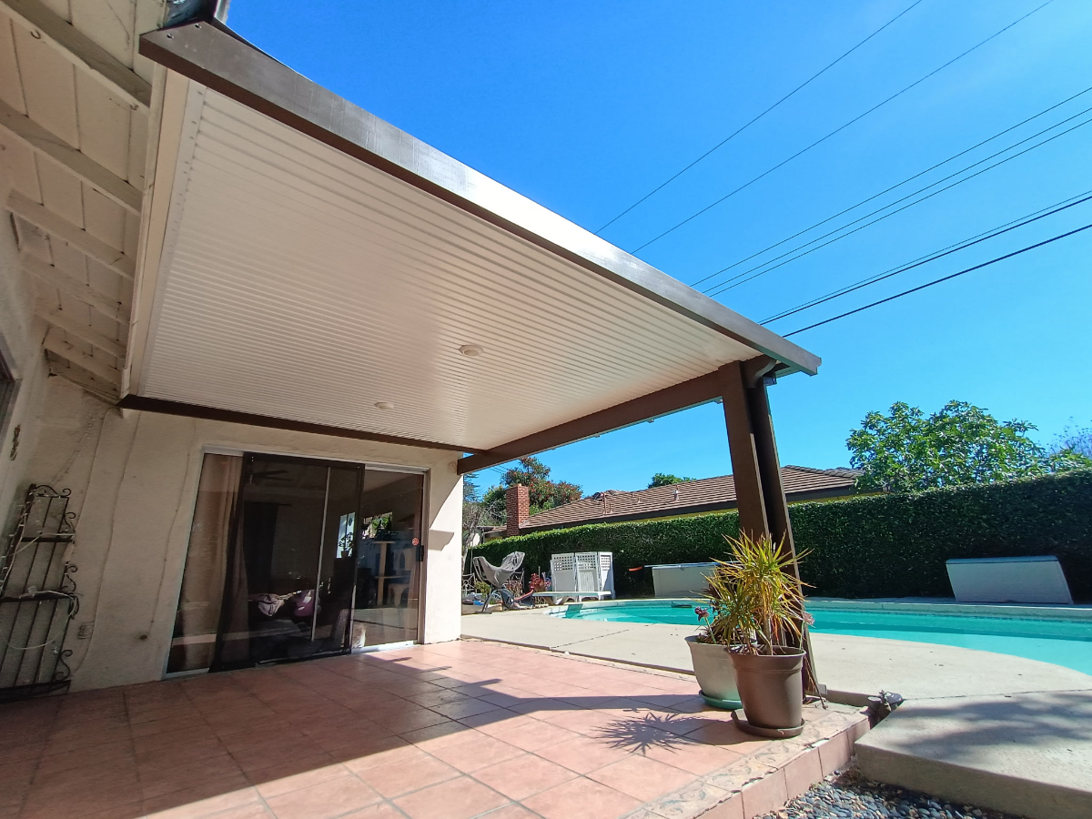 Attached aluminum patio cover with white finish over a residential back patio